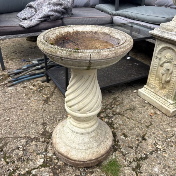 Classic cast stone garden bird bath with twist pedestal.