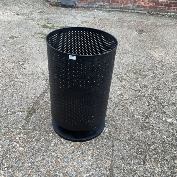 Perforated metal garden incinerator for outdoor waste burning.
