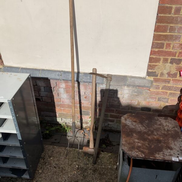 Vintage garden tools lot featuring a sledgehammer, pitchfork, and mattock.