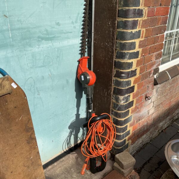 Gardena electric hedge cutter leaning against a wall.