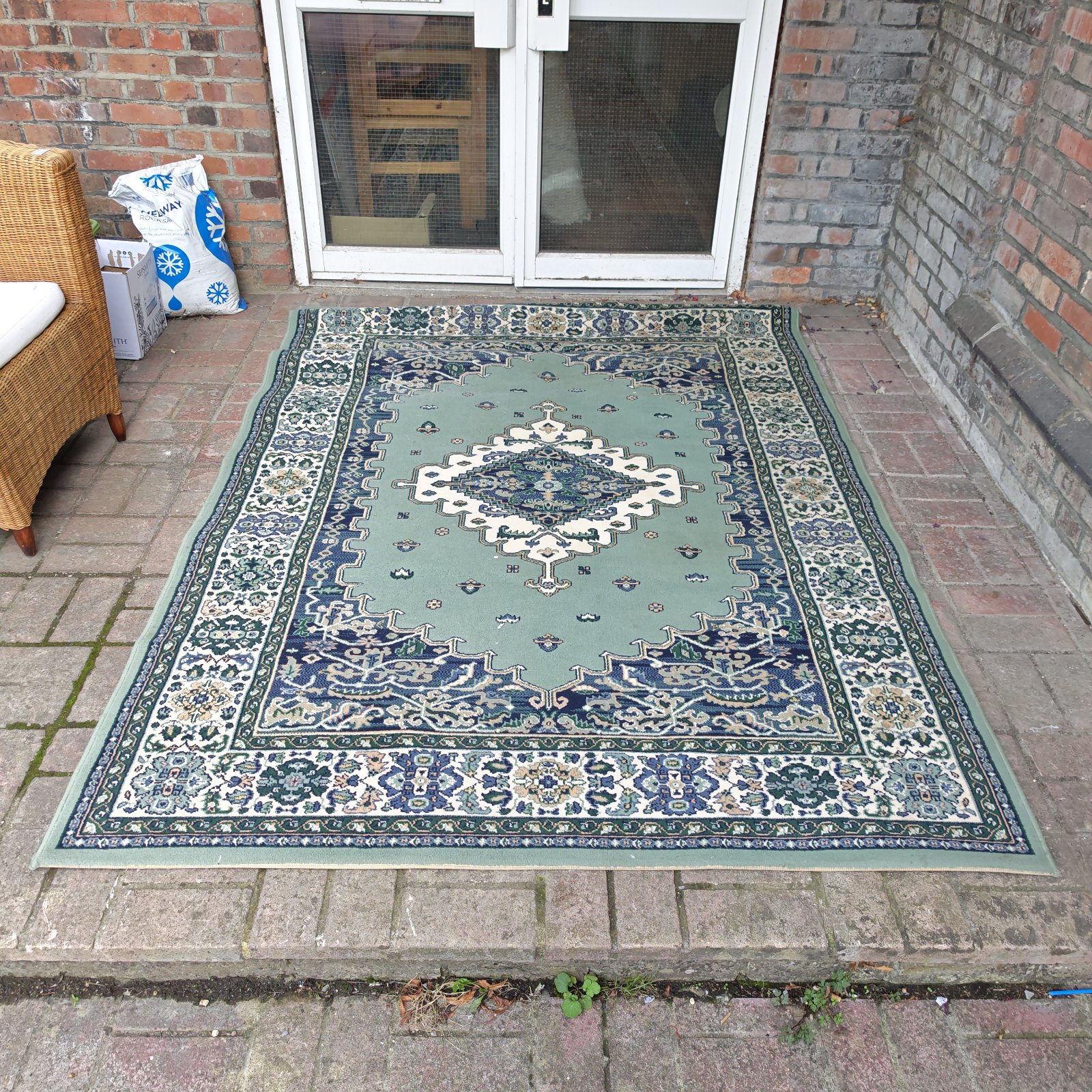 Large blue and green geometric pattern rug on display.