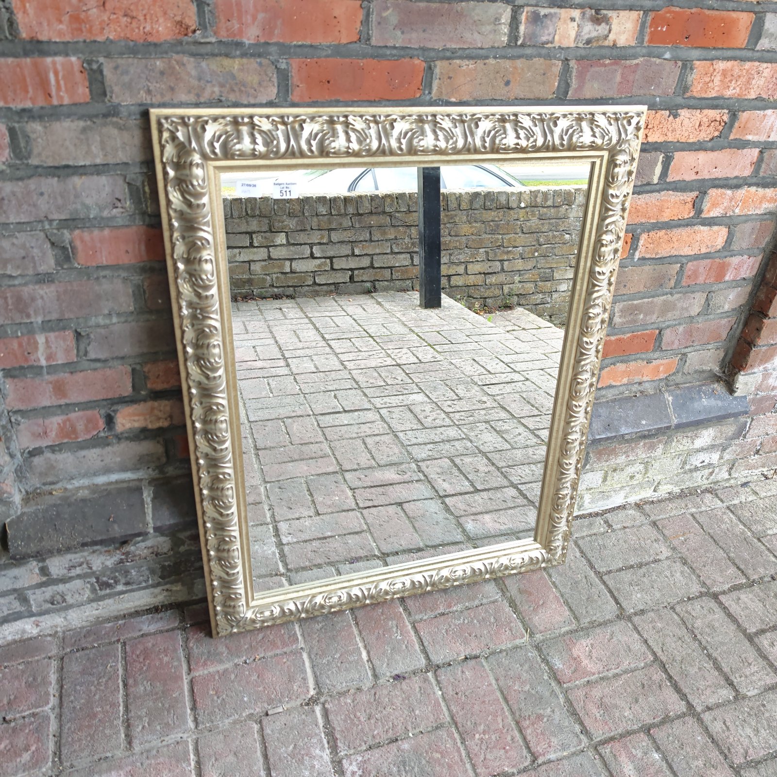 Ornate gilt framed wall mirror measuring 31 by 47 inches.