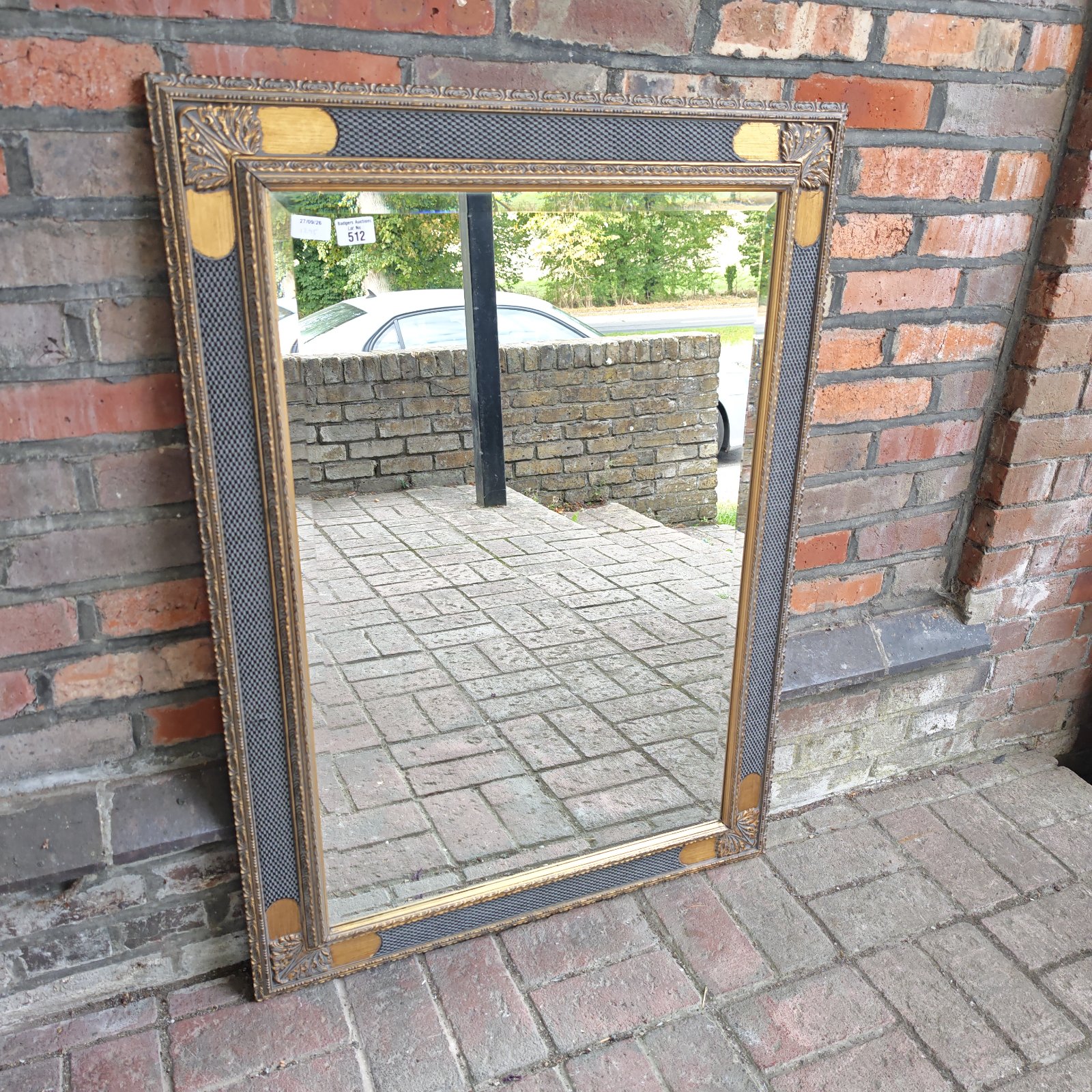 Ornate gilt framed overmantle mirror for wall display.