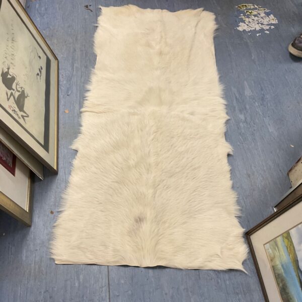 Cream and white natural goat skin rug for rustic home decor.
