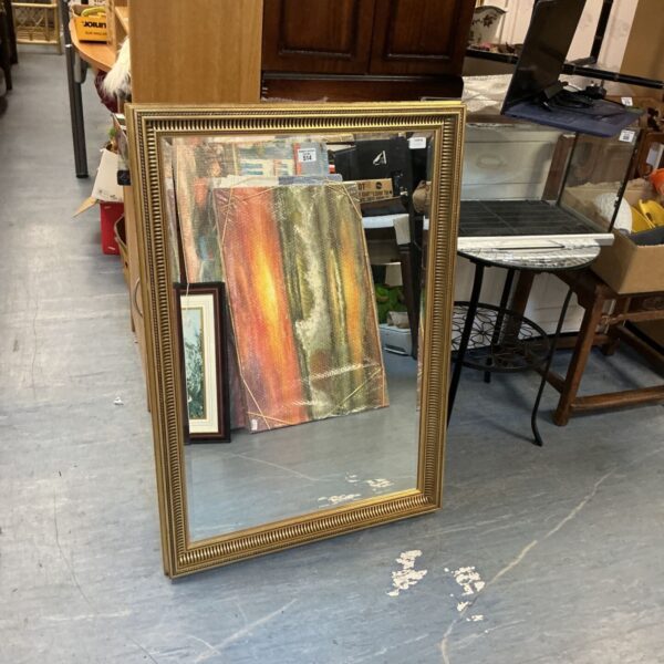 Large gold framed mirror for wall decoration.