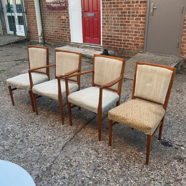 Set of four mid-century Gordon Russell dining chairs in a garden.