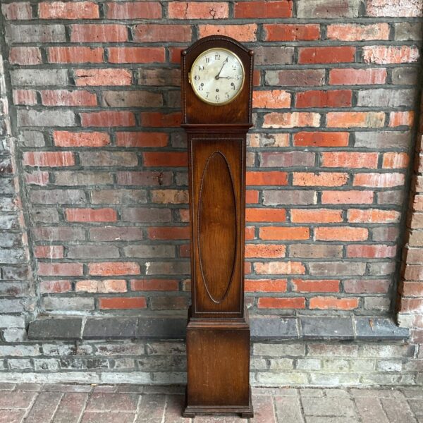 Antique grandfather clock with brass dial and wooden case.