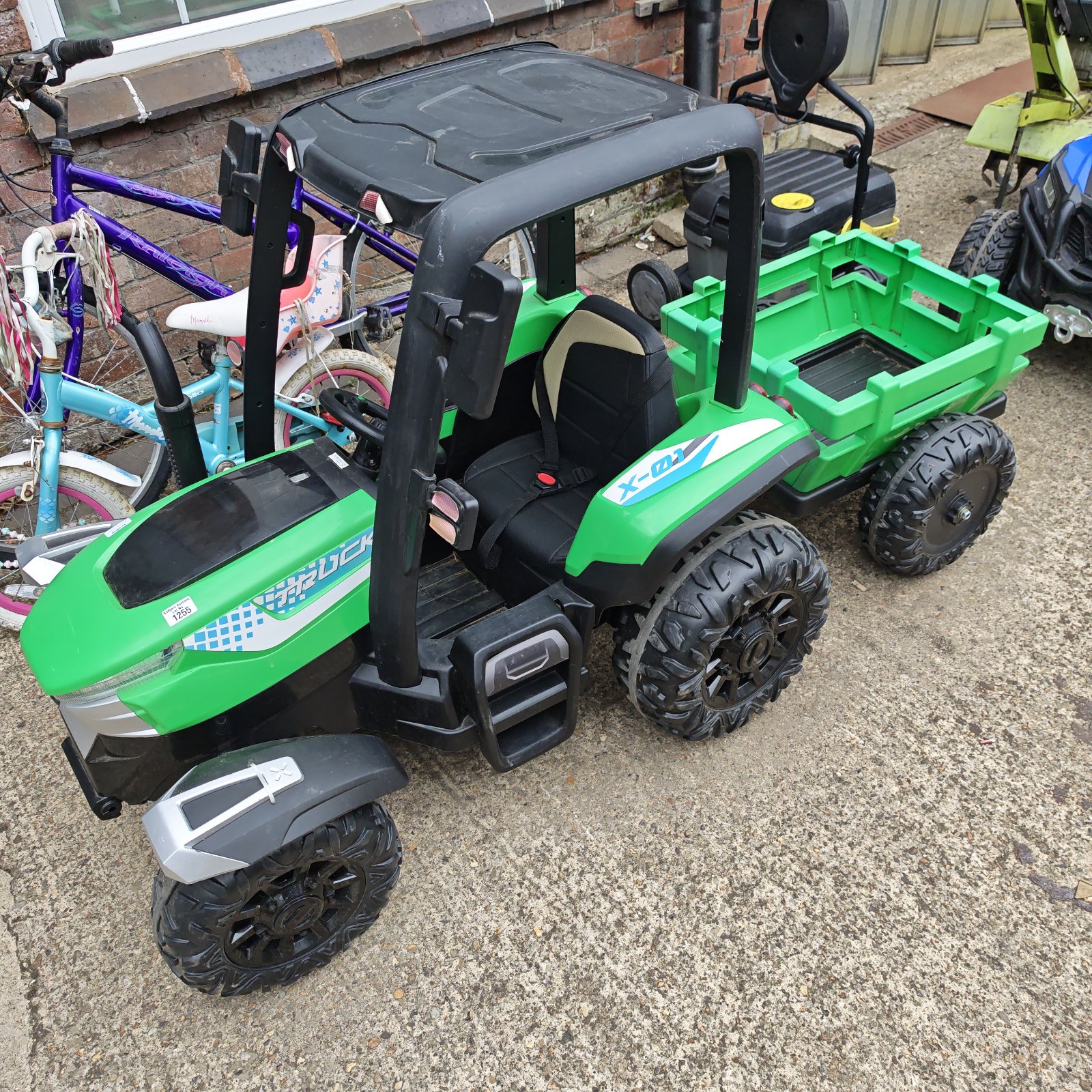 Green ride on tractor with trailer hitch for kids.