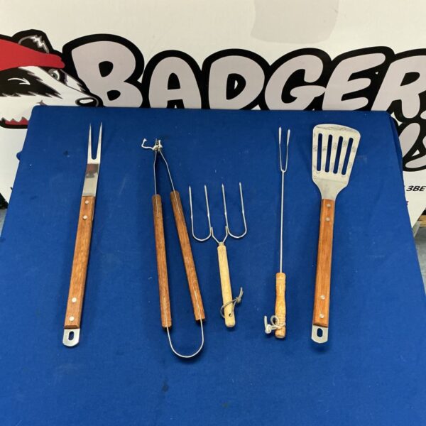 Vintage grilling tongs and spatula with wooden handles.