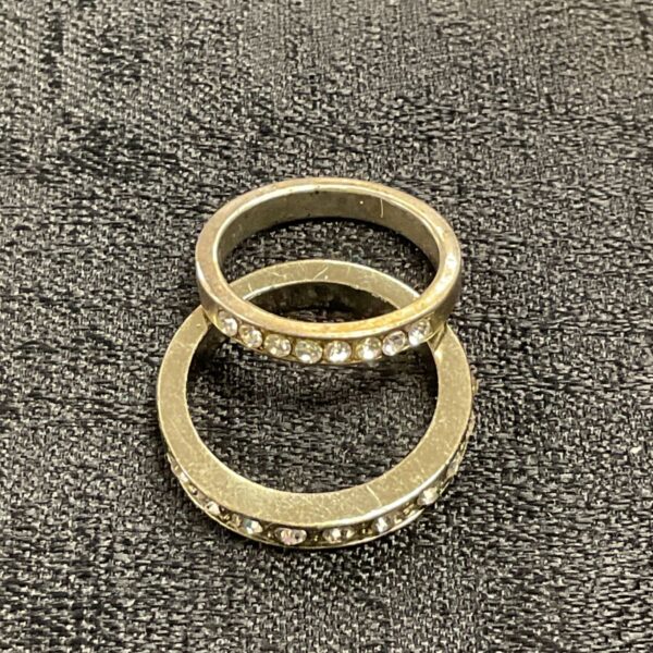 Gold tone half eternity rings with white stone settings.