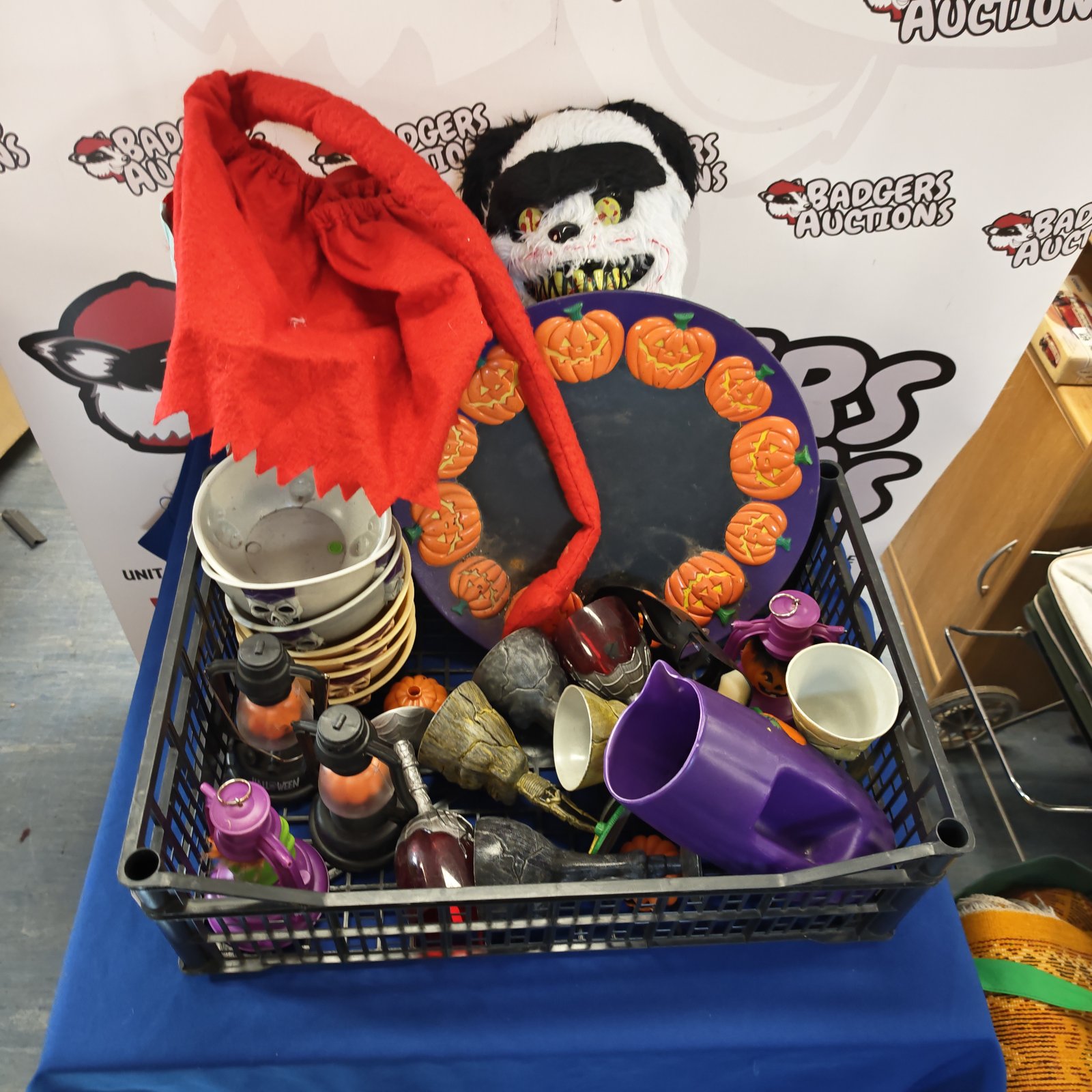 Mixed Halloween costume and decoration lot with cape and pumpkins.