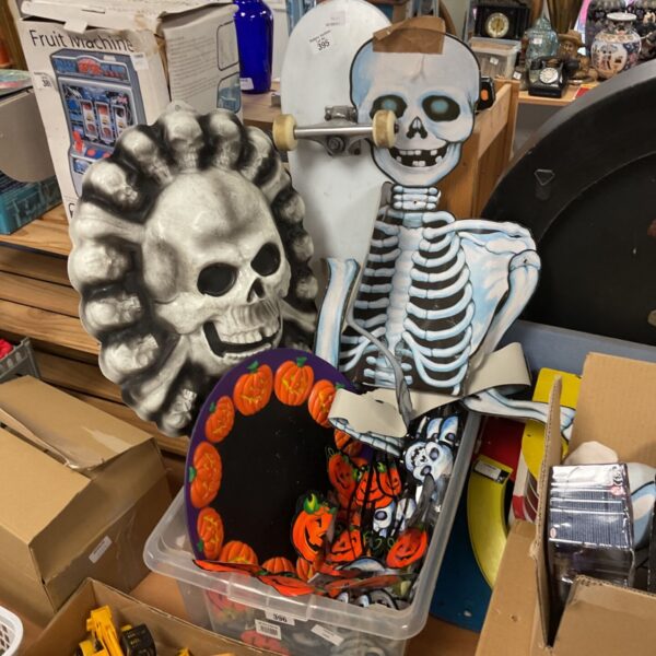 Box of assorted Halloween decorations with a skull and pumpkins.