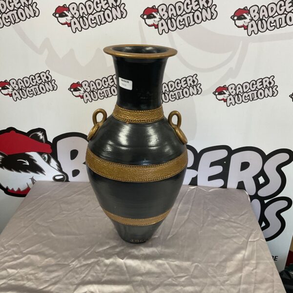Tall handmade pottery urn with dark glaze and decorative details.