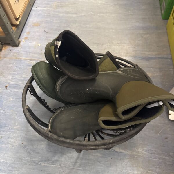 Wrought iron hanging baskets with gardening boots for garden display.