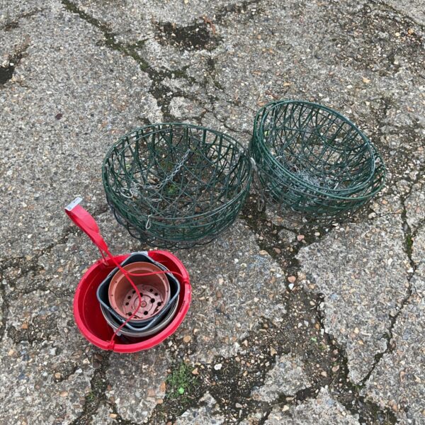 Collection of hanging garden baskets and terracotta plant pots.