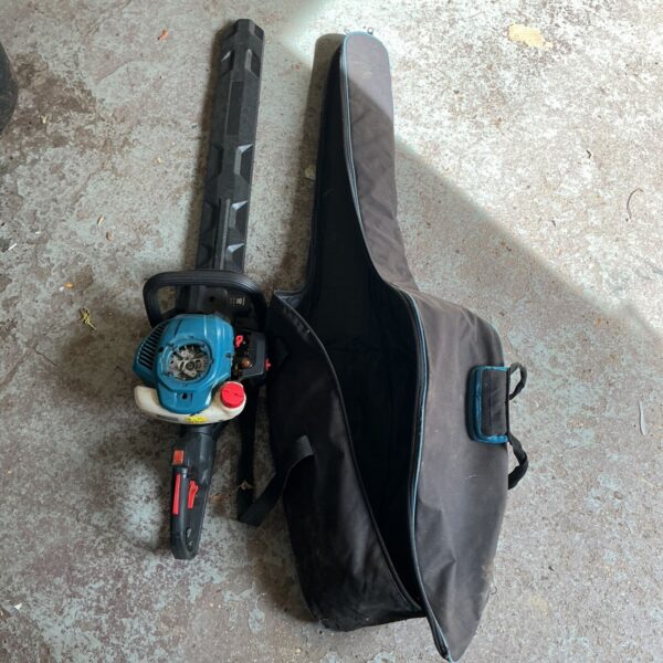 Black and green hedge trimmer with a carrying bag.