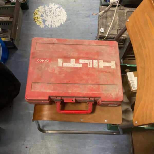 Red Hilti DX400 nail gun case with wear and tear.