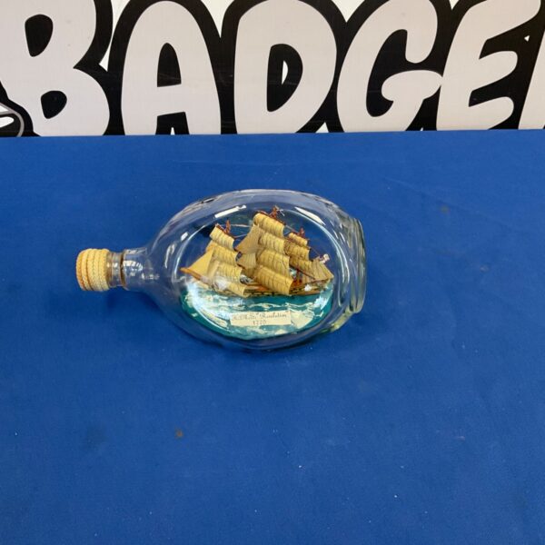 Detailed HMS Resolution ship in a bottle, a nautical collectible.