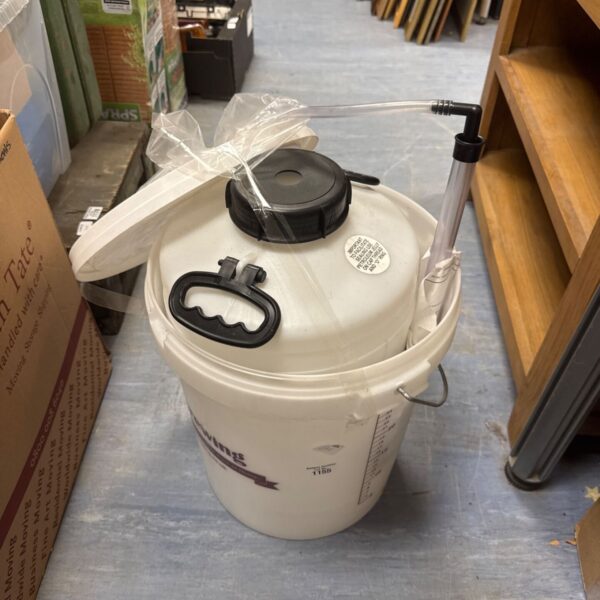 Plastic home brewing fermenter bucket with lid.