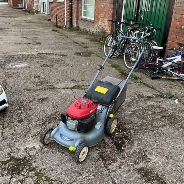 Honda Izy petrol lawn mower in a garden setting.