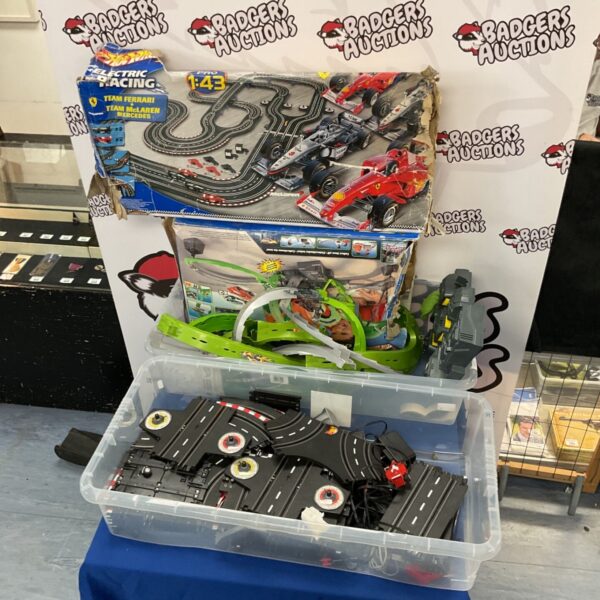 Two Hot Wheels electric racing sets with track pieces.