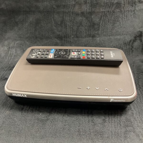 Humax Freeview Play box with remote control on a dark surface.
