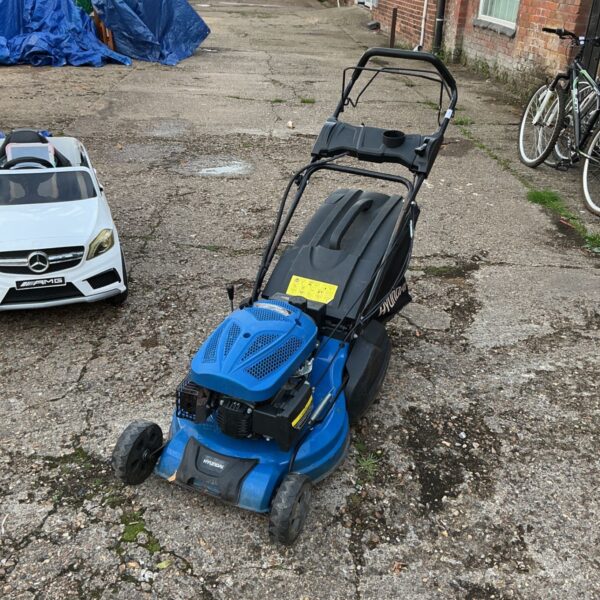 Used Hyundai petrol lawnmower in a garden setting.