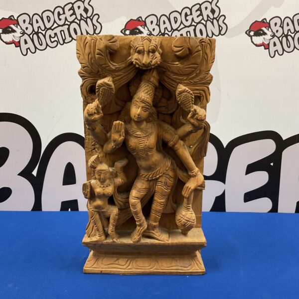 Intricate Indian wood carving relief of a dancing deity.