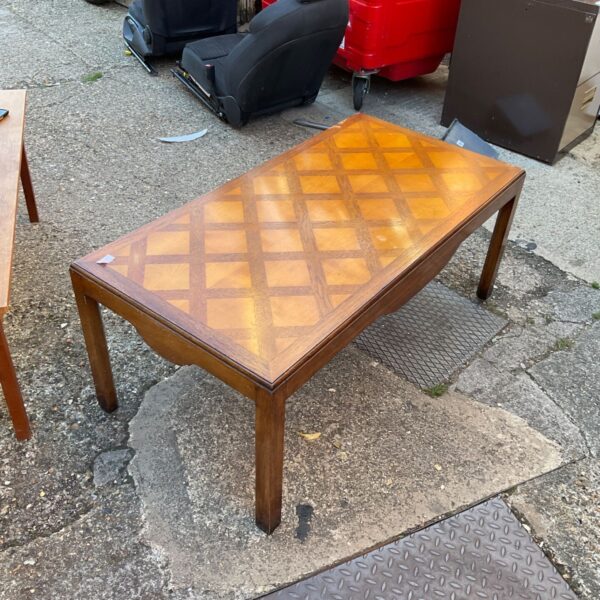 Vintage inlaid coffee table with geometric wood design.
