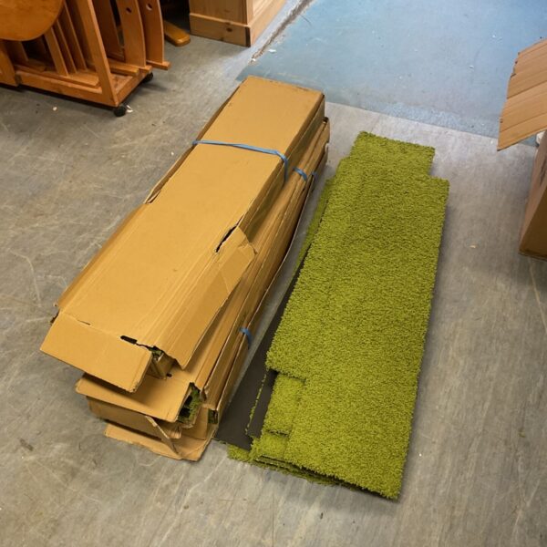 Green Interface carpet strips for modular flooring, showing signs of wear.