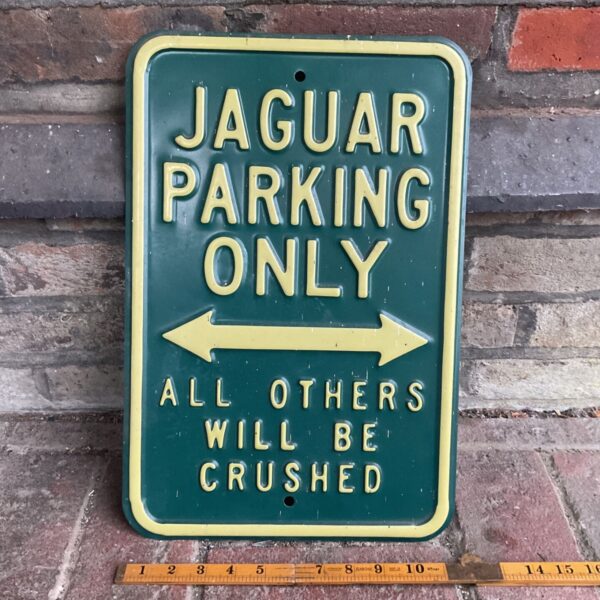Vintage metal Jaguar parking sign with a humorous warning.