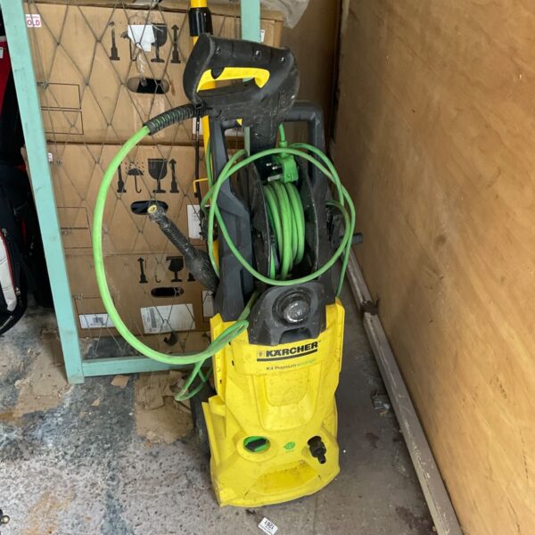 Yellow Karcher power washer with handle and hose connection.
