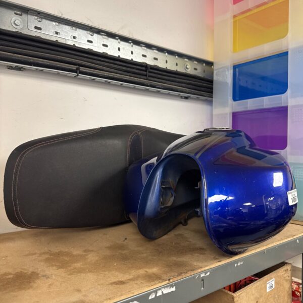 Blue Keeway fuel tank and seat on a metal shelf.