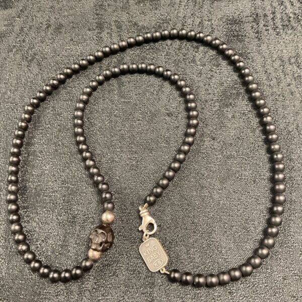 Black onyx King Baby necklace looped, showing the jet skull charm.