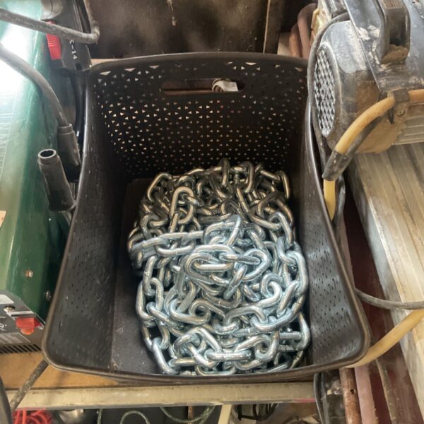 Large metal chain stored in a black plastic box.
