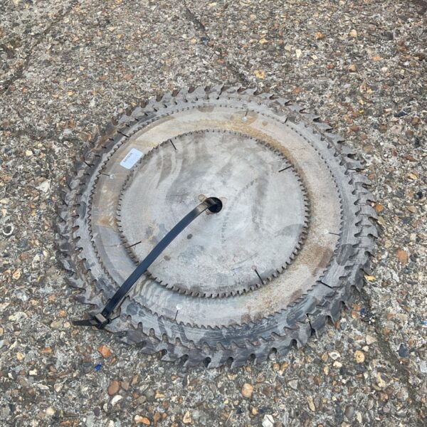 Large circular saw blade with worn teeth, industrial cutting tool.