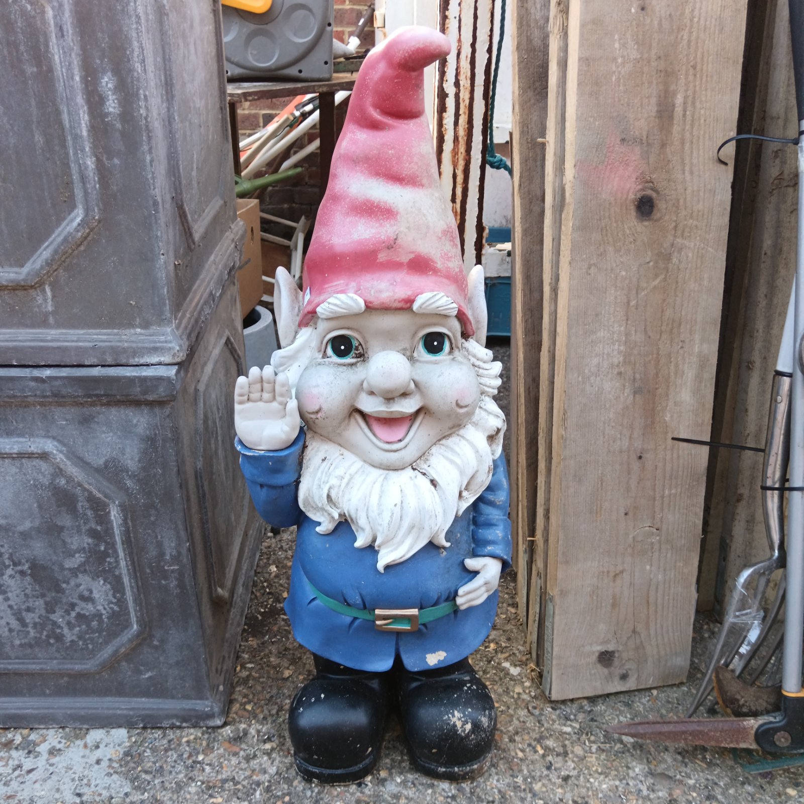 Large fibreglass garden gnome in a garden setting.