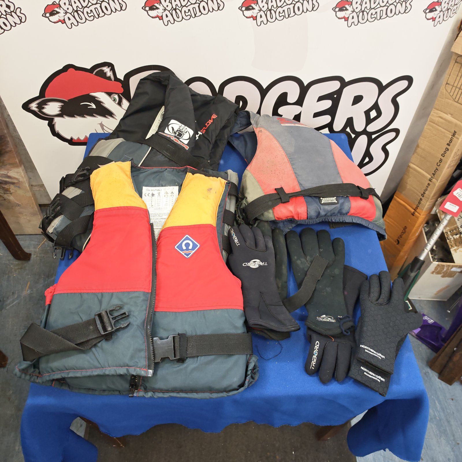 Life preserver lot with diving gloves, marine safety equipment.