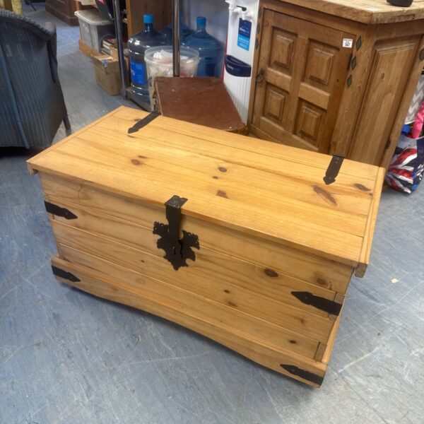 Light oak blanket box on wheels, ideal for bedroom storage.