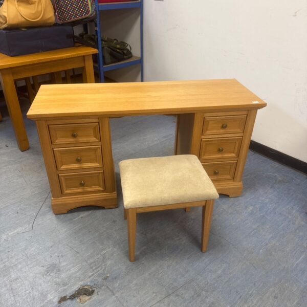 Vintage light oak dressing table with matching stool in a bedroom setting.