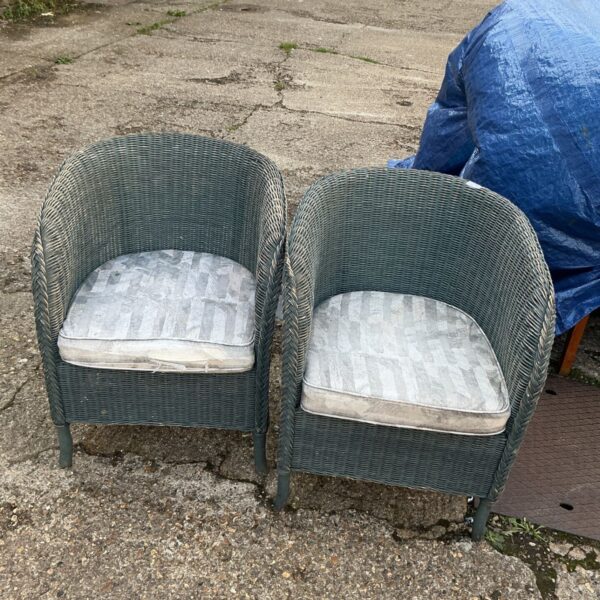 Pair of vintage Lloyd Loom style garden chairs in a garden setting.