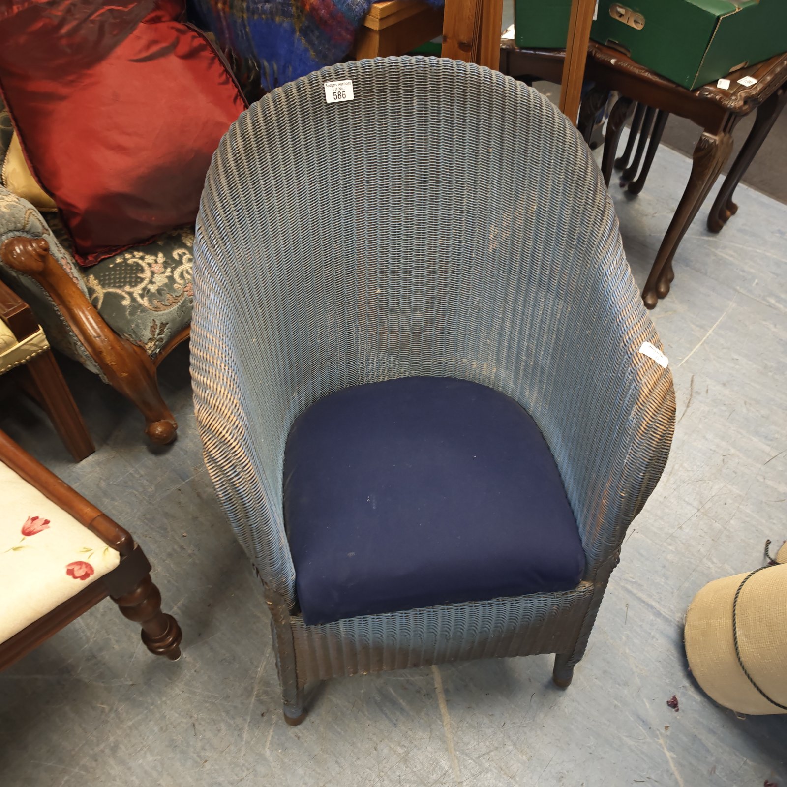 Vintage Lloyd Loom tub chair with a blue cushion, retro seating.