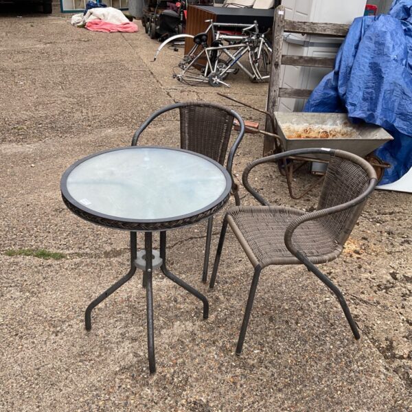 Two garden chairs and glass topped table