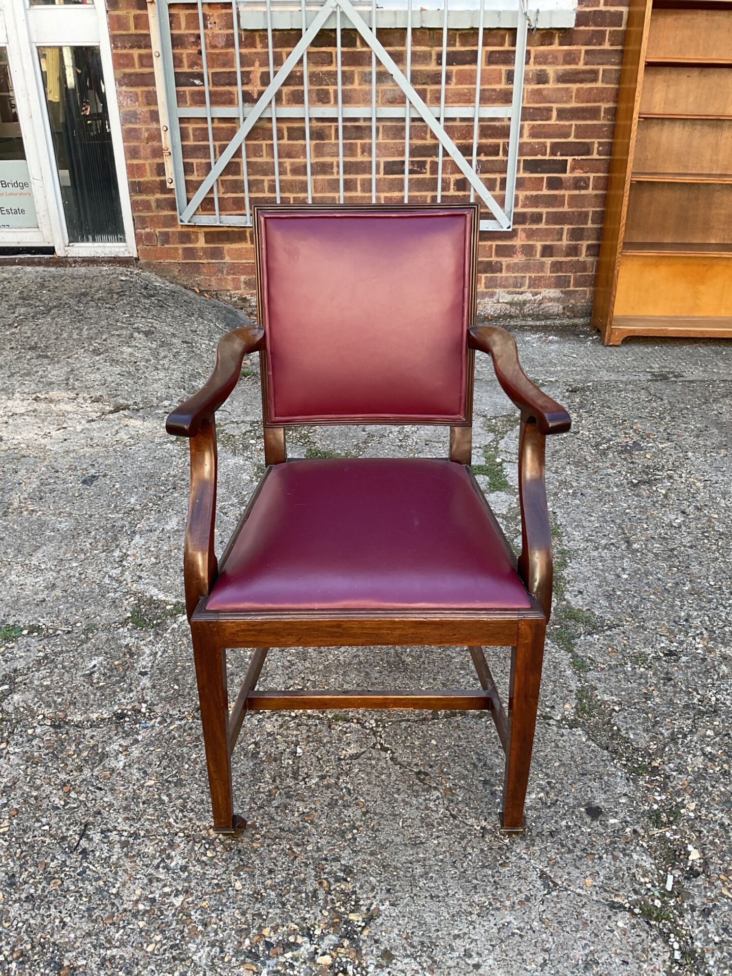 1379 Vintage mahogany carver armchair featuring burgundy leather upholstery & caster wheels