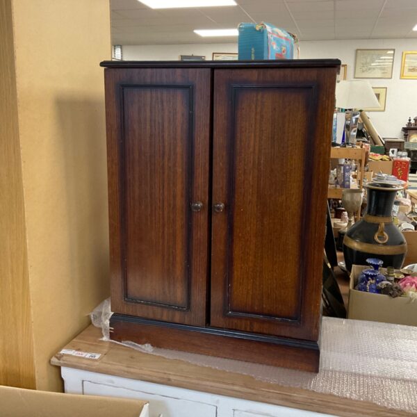 Dark mahogany CD cupboard with two doors.