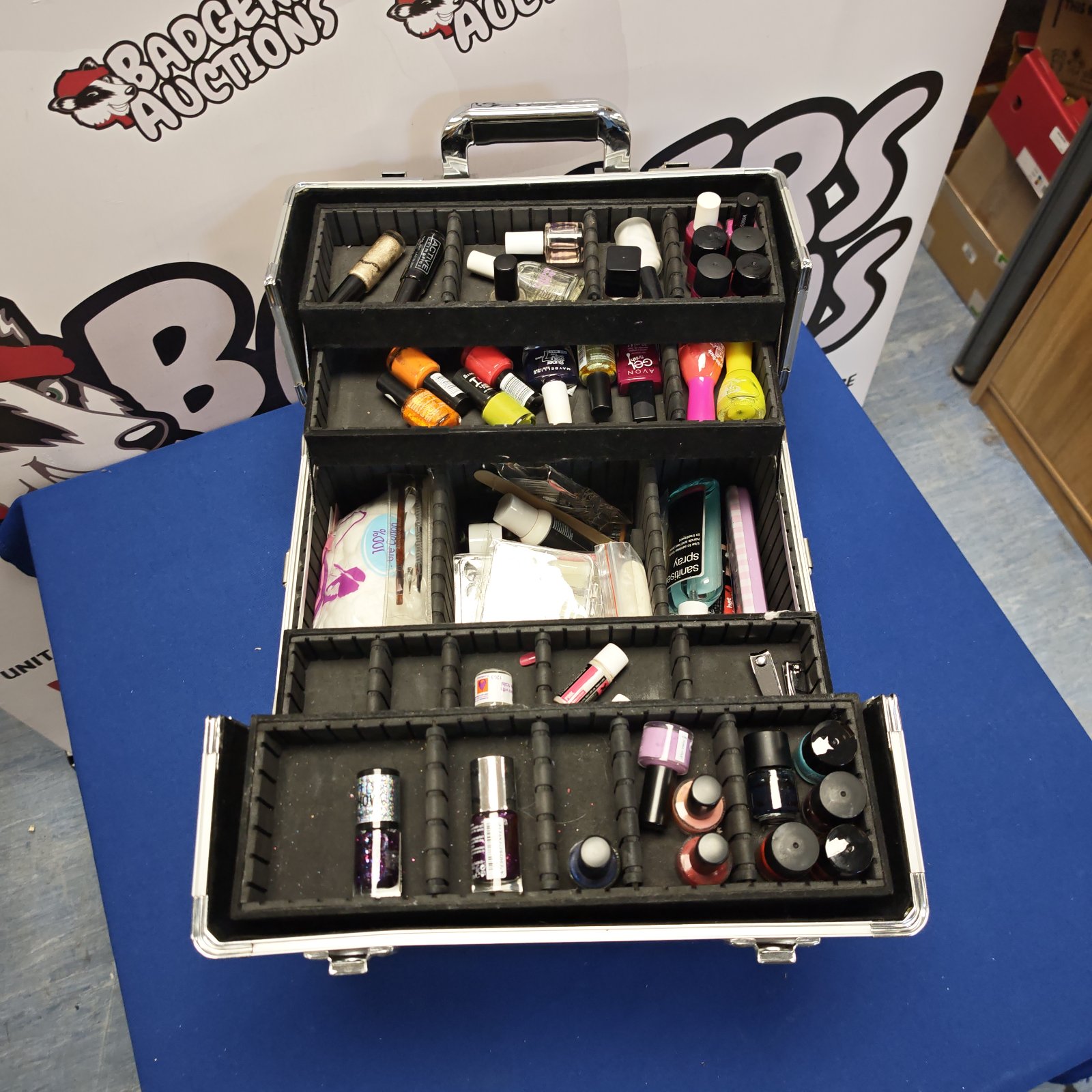 Open makeup case showing nail polish and cosmetics.