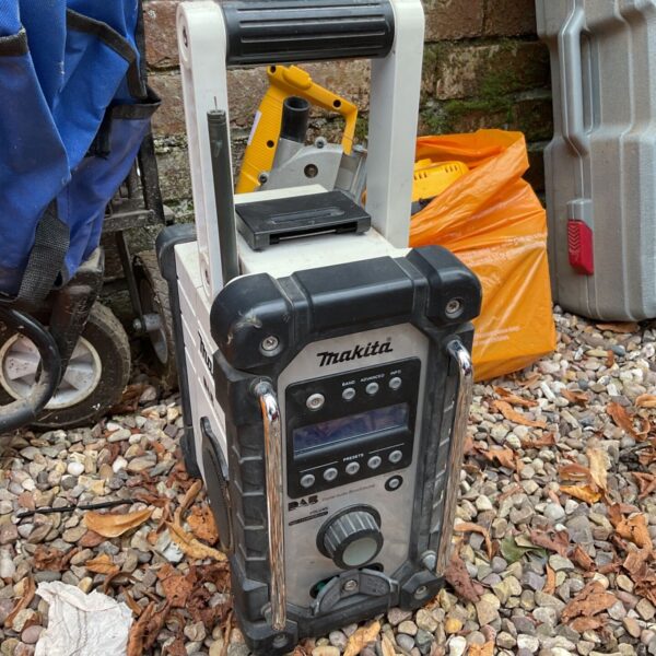 Makita DAB site radio on a garden surface.