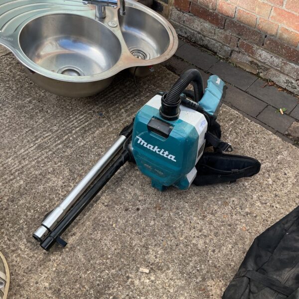 Makita hepa filter vacuum with attachment, cordless dust extraction tool.