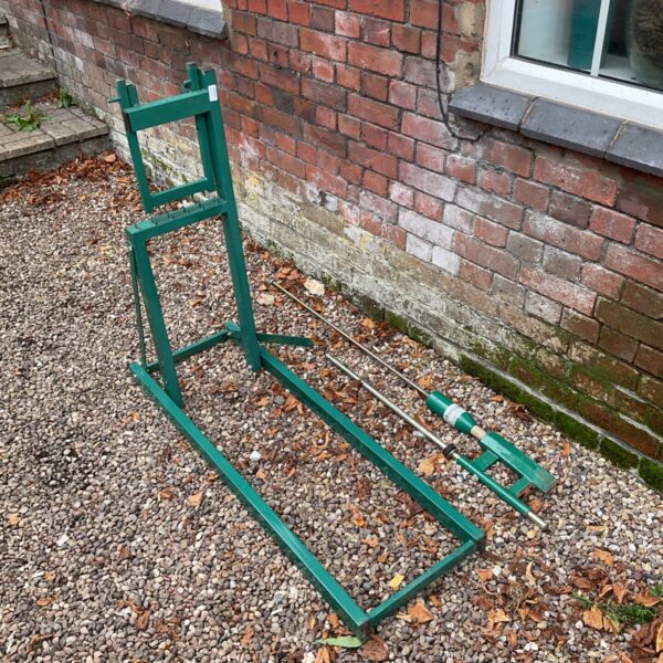 Green manual log splitter for splitting firewood in a garden.