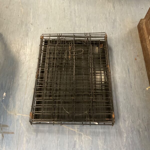 Vintage metal animal cage for small pets, showing signs of wear.